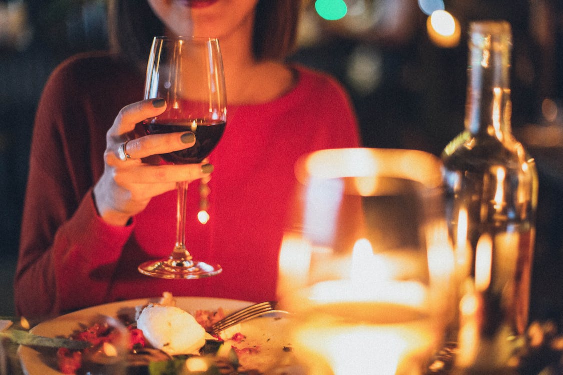 A woman is drinking wine on a dinner date
