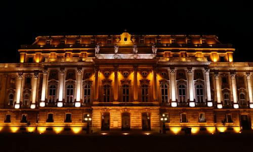 the exterior of a brown building illuminated with lights