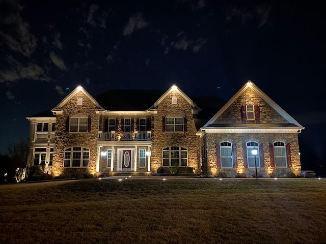 Completed outdoor lighting project for a residential home, illuminating pathways, landscaping, and architectural features