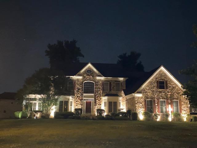 Home exterior beautifully lit by outdoor lighting at night