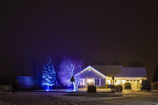 A well-lit home with outdoor lighting on the patio highlighting its architecture.