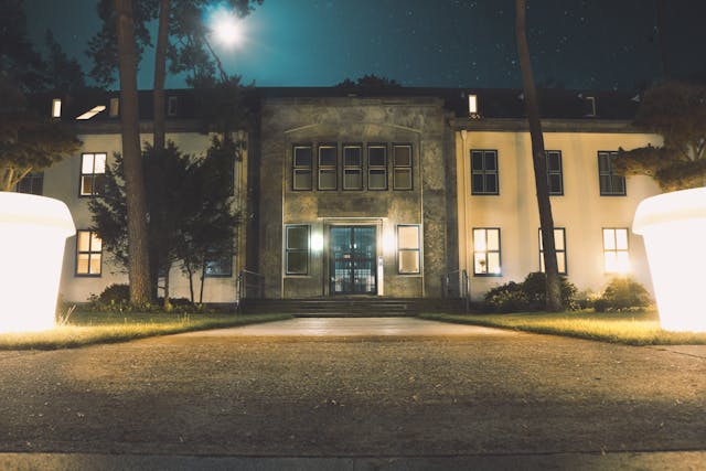 An outside view of a beautiful home with warm landscape lighting