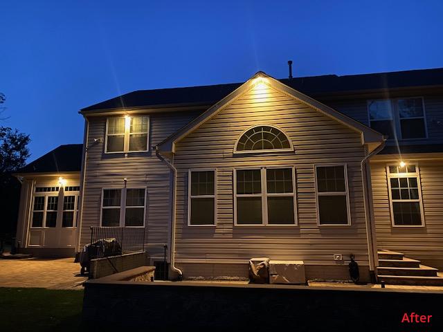 Elegant house exterior illuminated with warm outdoor lighting at night