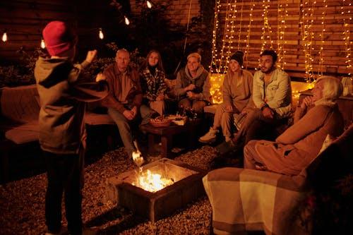 Group of people enjoying a backyard bonfire with strategic lighting